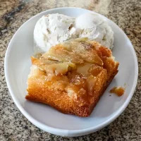 Butterscotch apple crumble with vanilla ice cream on a white dish.