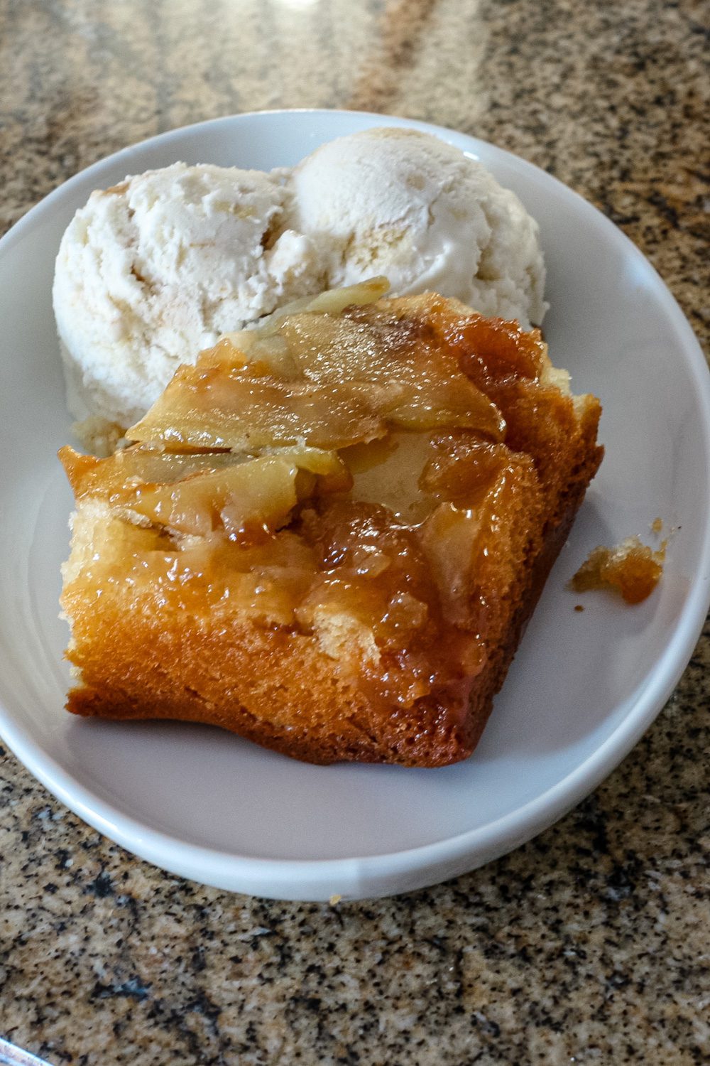 a slice of apple upside down cake with ice cream on the side