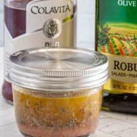 Canned tomato mixture with seasoning in a glass jar.