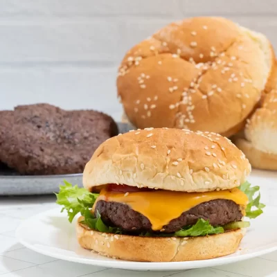 Golden sesame seed bun with a juicy cheeseburger and fresh lettuce.