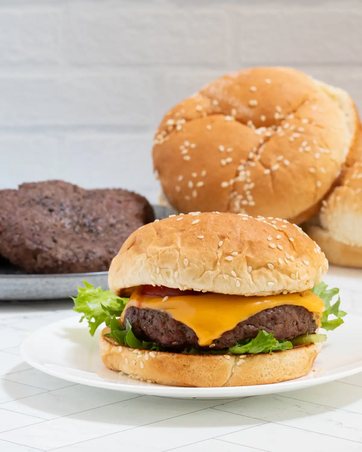 Golden sesame seed bun with a juicy cheeseburger and fresh lettuce.
