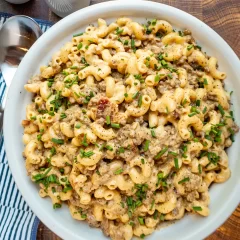 Creamy ground beef and macaroni casserole garnished with chopped chives.