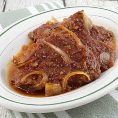 baked cube steaks with bbq sauce on a platter