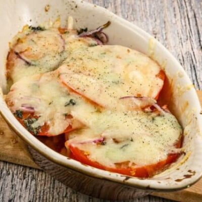 fresh baked tomatoes in a gratin dish with melted fontina cheese