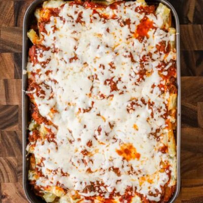 Baked ziti vertical photo on a cutting board.