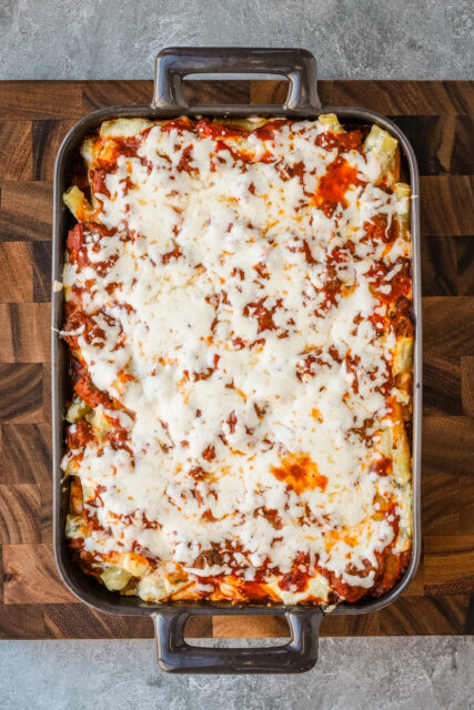 Baked ziti vertical photo on a cutting board.