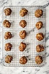 A tray of freshly cooked meatballs on a wire cooling rack.