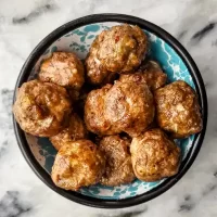 Juicy homemade meatballs in a black bowl.