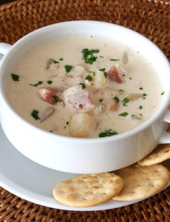 A bowl of clam chowder with crackers