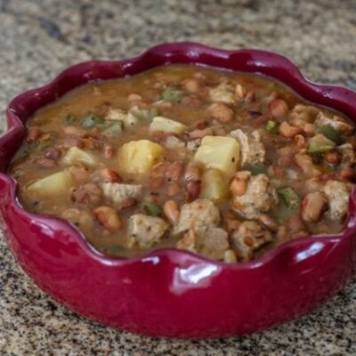 slow cooker pineapple beans with sausage in a serving dish