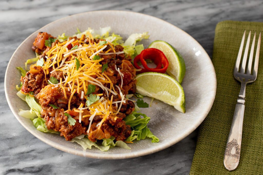 beef and bean taco casserole on a plate with lettuce