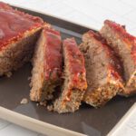 classic beef and pork meatloaf on a serving tray, sliced