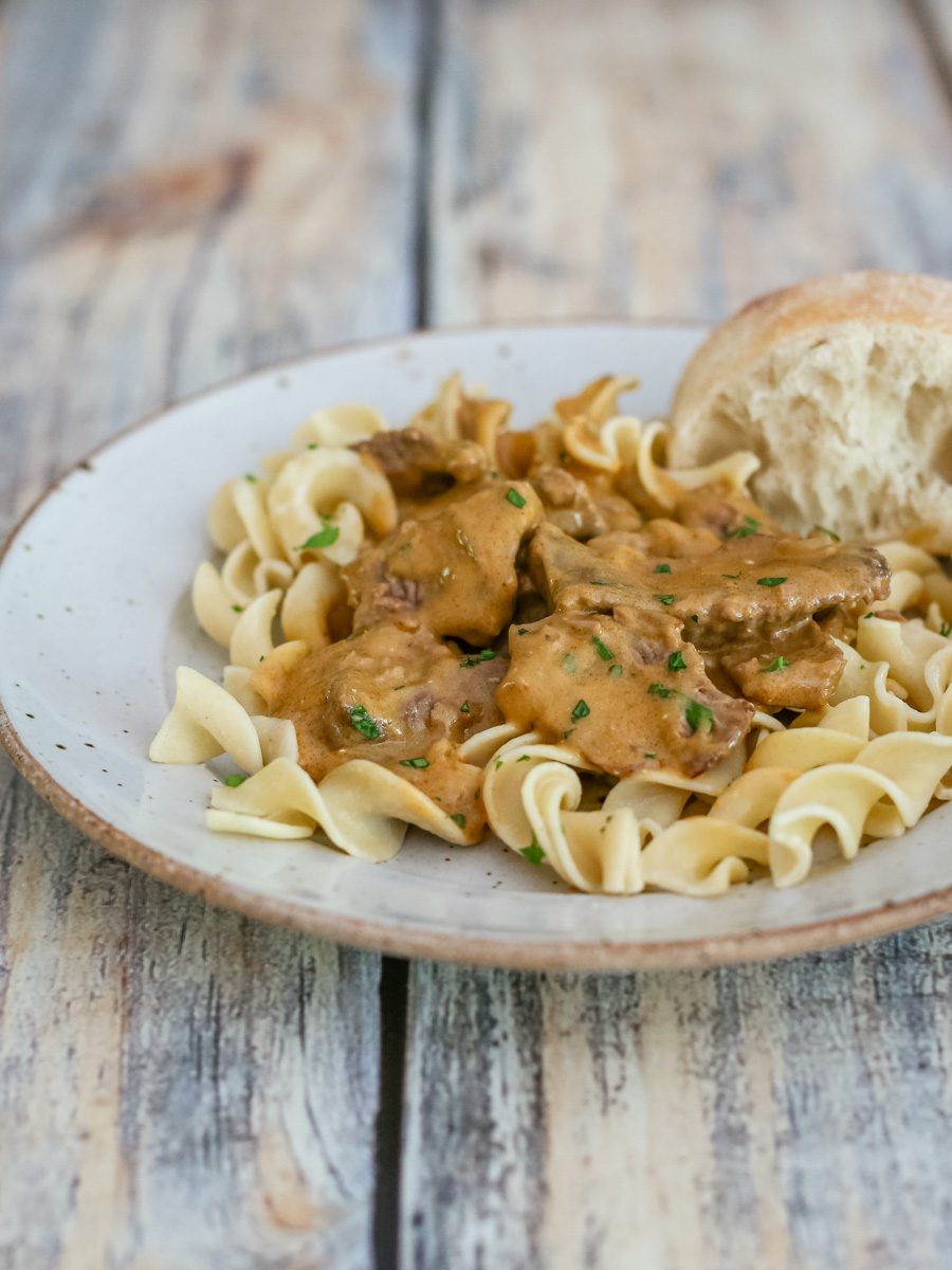 a plate of beef stroganoff on noodles