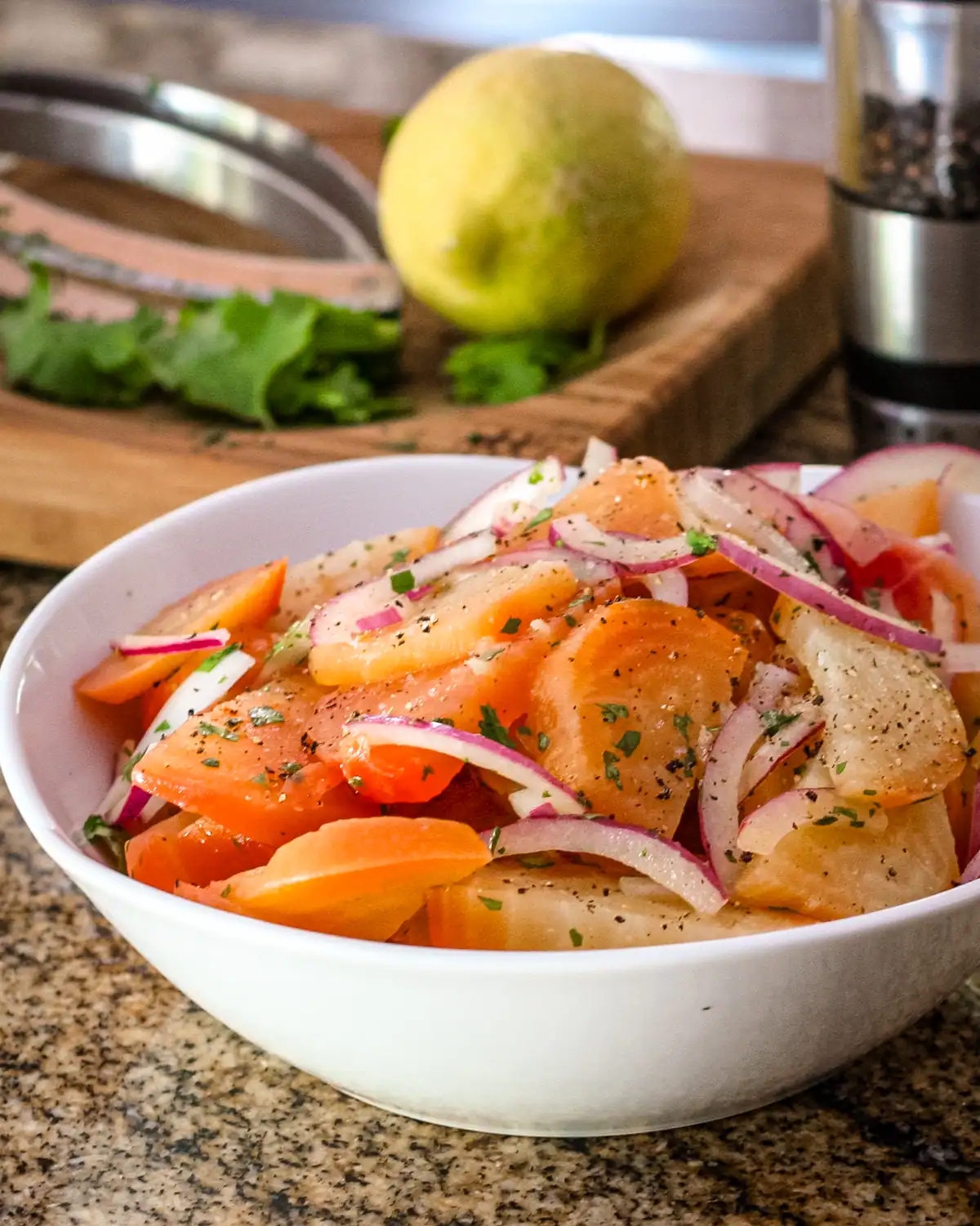 Freshly prepared carrot and onion salad in a white bowl.