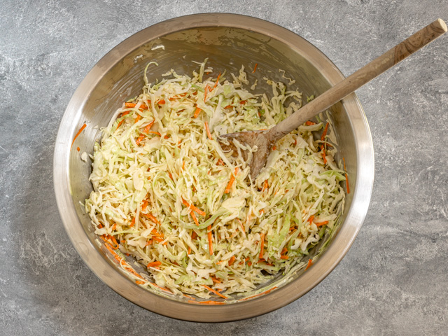 Mixing classic creamy coleslaw in a bowl