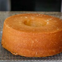 Golden-brown sponge cake on cooling rack.