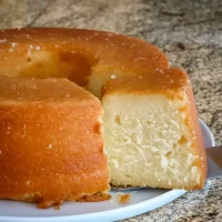 Classic creamy cheesecake with a golden crust on a white plate.