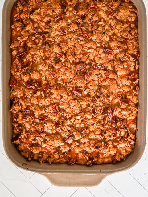 A baked sweet potato casserole with pecan topping.