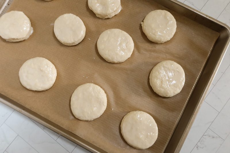 The dough is completed and the biscuits are cut out and brushed with cream