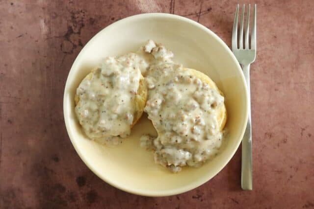 A bowl with biscuits and gravy.