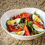 Bbq chicken chopped salad with hard-boiled eggs and fresh vegetables.