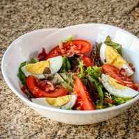 Bbq chicken chopped salad with hard-boiled eggs and fresh vegetables.