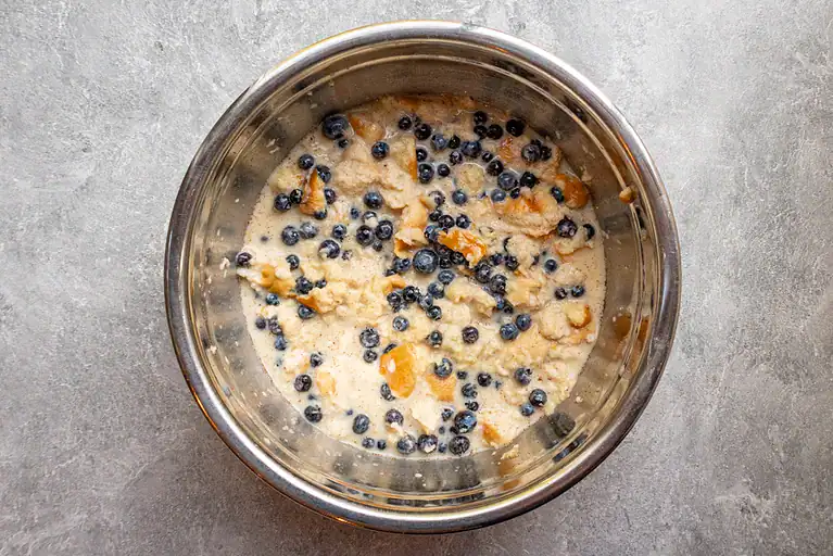 Creamy blueberry muffin batter with pieces of fruit and blueberries.