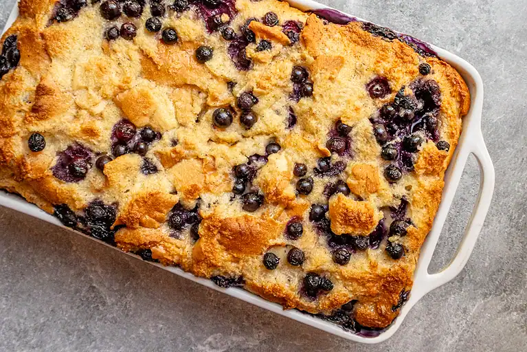 Sweet blueberry cobbler with golden topping in baking dish.