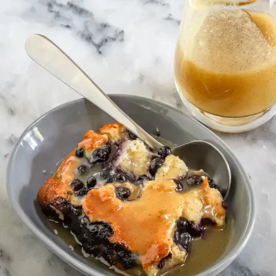 Sweet blueberry cobbler with caramel sauce drizzled on top.