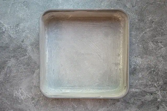 Greased and floured 9-inch baking pan for blueberry crumb cake.