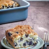 Blue ceramic baking dish with blueberry crumb cake.