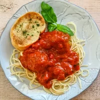 Savory spaghetti with meatballs and marinara sauce on a decorative plate.