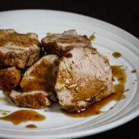 Pork tenderloin on a plate with bourbon and cola glaze.