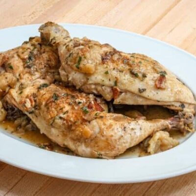 oven braised chicken with bacon and apples on a serving platter