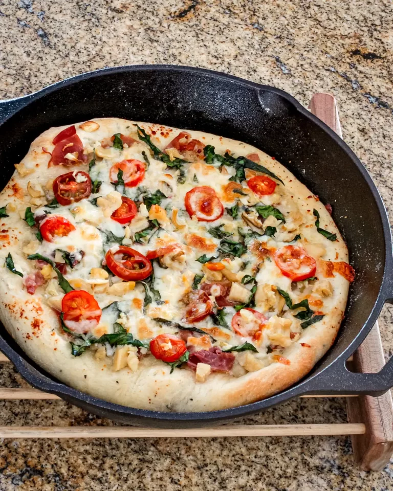 Cheese pizza topped with cherry tomatoes and fresh basil leaves.