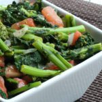 broccoli raab cooked with garlic and tomatoes in a serving bowl