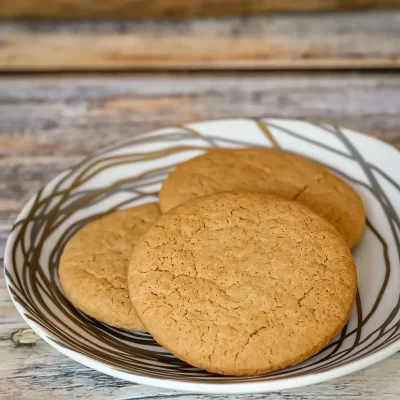 Freshly baked classic sugar cookies on a striped bowl.