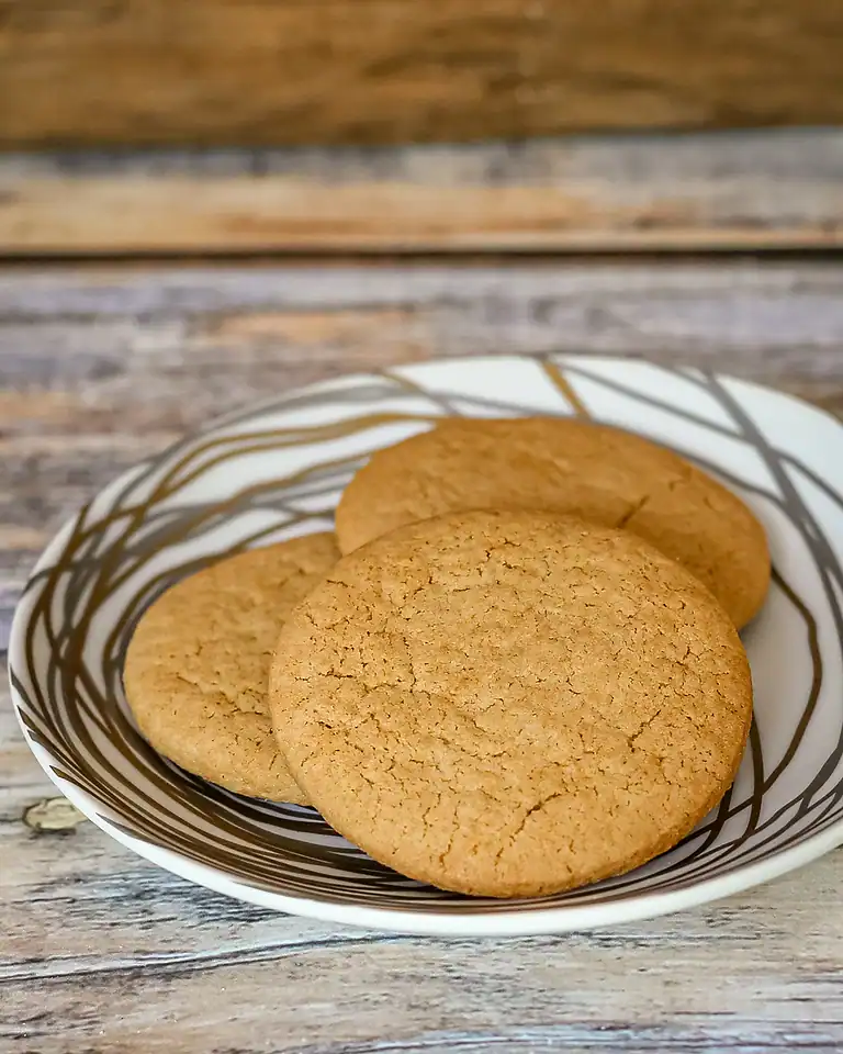 Freshly baked classic sugar cookies on a striped bowl.