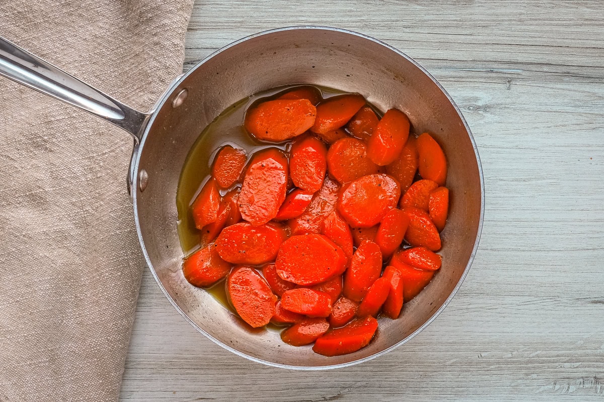 A saucepan with buttery brown sugar glazed carrots.