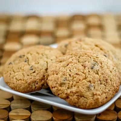 Freshly baked chocolate chip cookies on a white plate.