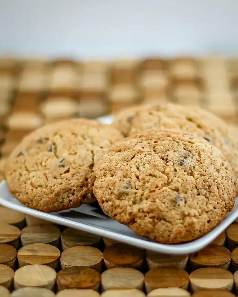 Freshly baked chocolate chip cookies on a white plate.