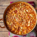 brunswick stew made with chicken thighs and pork in a dutch oven