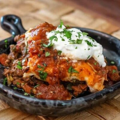 burrito casserole in a serving dish with a dollop of sour cream