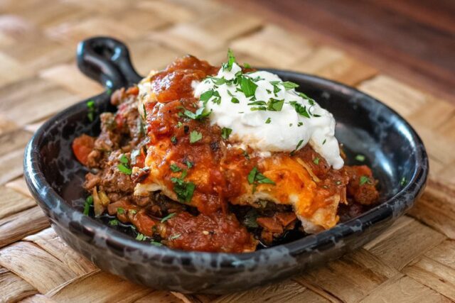 burrito casserole in a serving dish with a dollop of sour cream