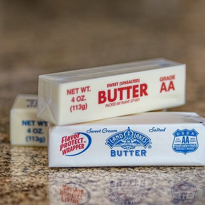 Sticks of butter on the counter, showing unsalted and salted.