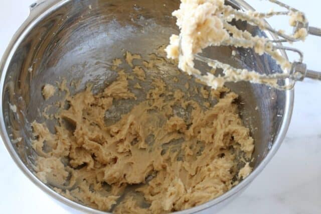 Cookie dough in mixing bowl with beaters.