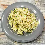 Fettuccine pasta garnished with chopped parsley on a gray plate.