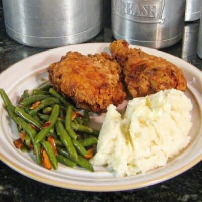 Plate with buttermilk fried chicken, mashed potatoes, and green beans