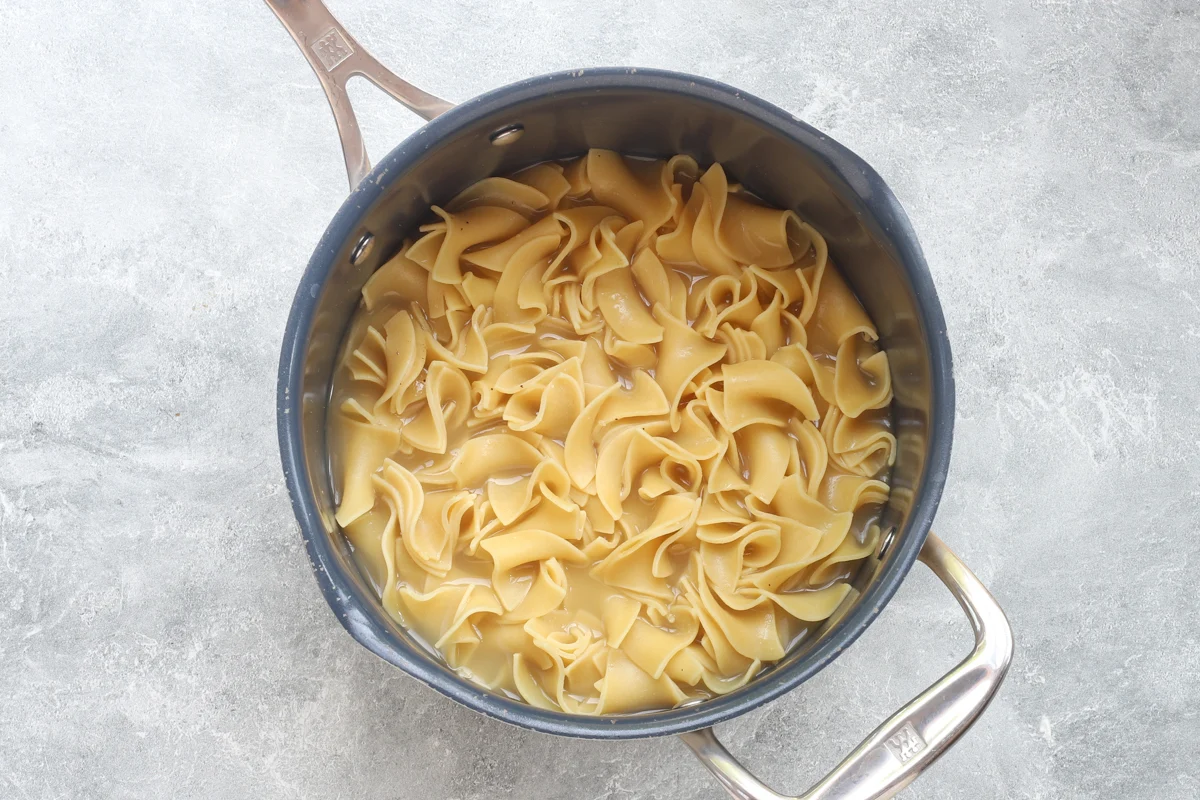 Cafeteria noodles cooking in a saucepan.