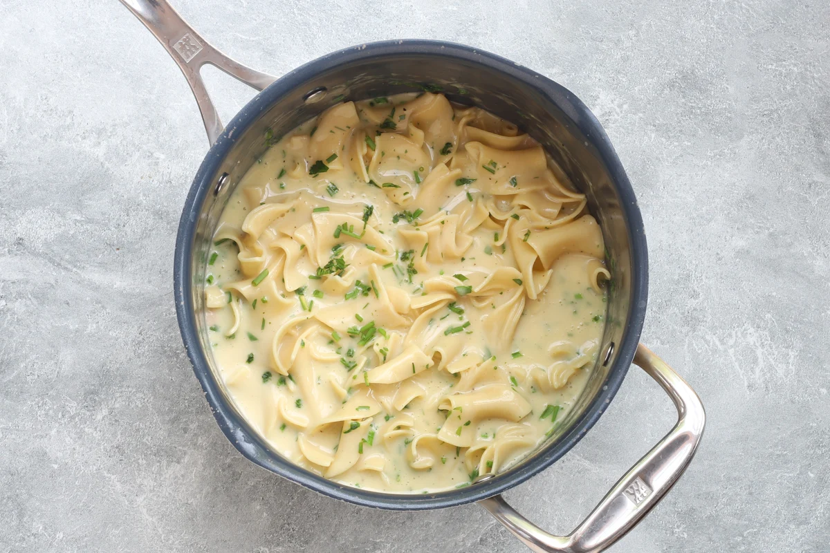 Cafeteria noodles simmering with condensed soup and herbs and butter.